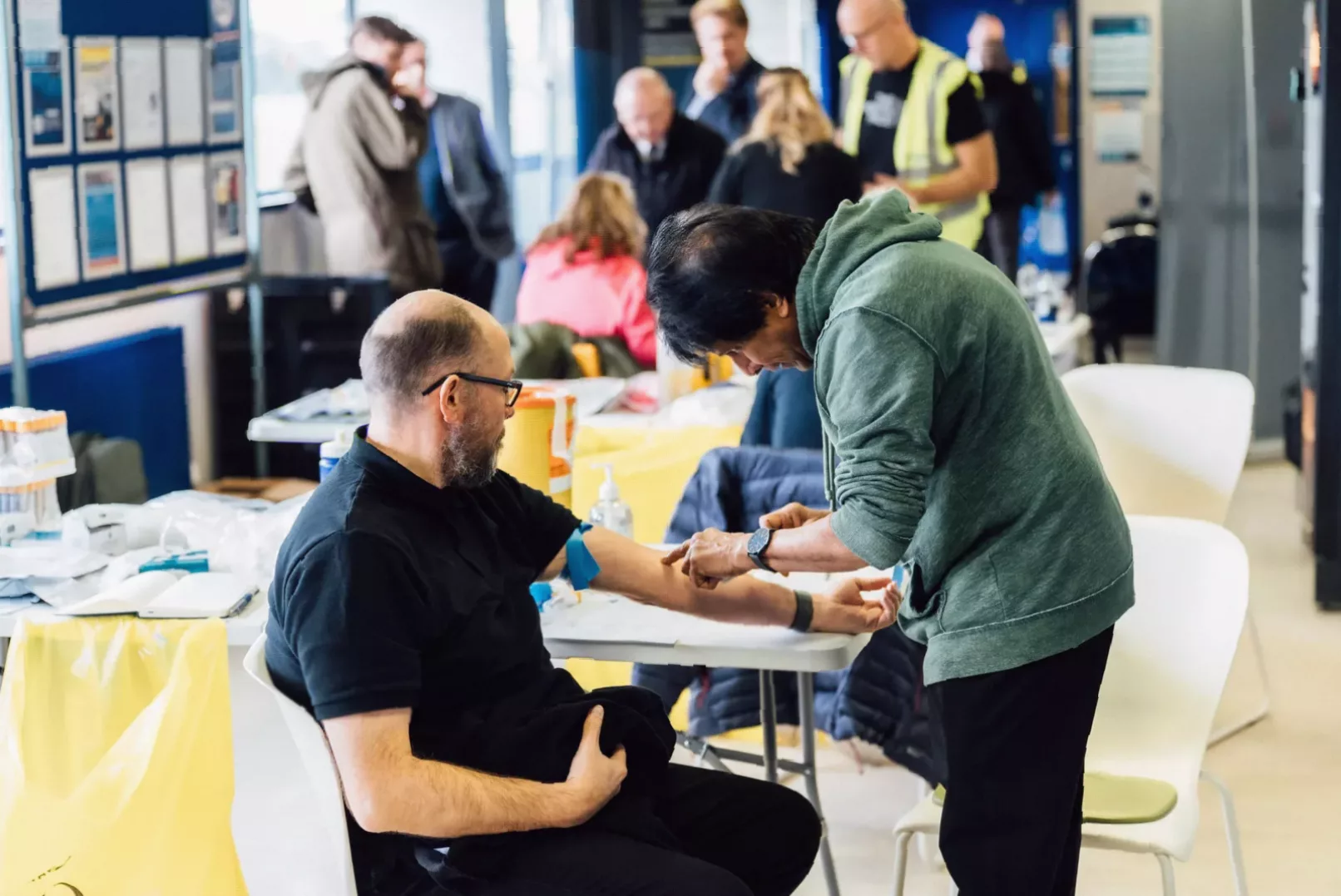 Men attending a community health event for cancer awareness in Scotland.