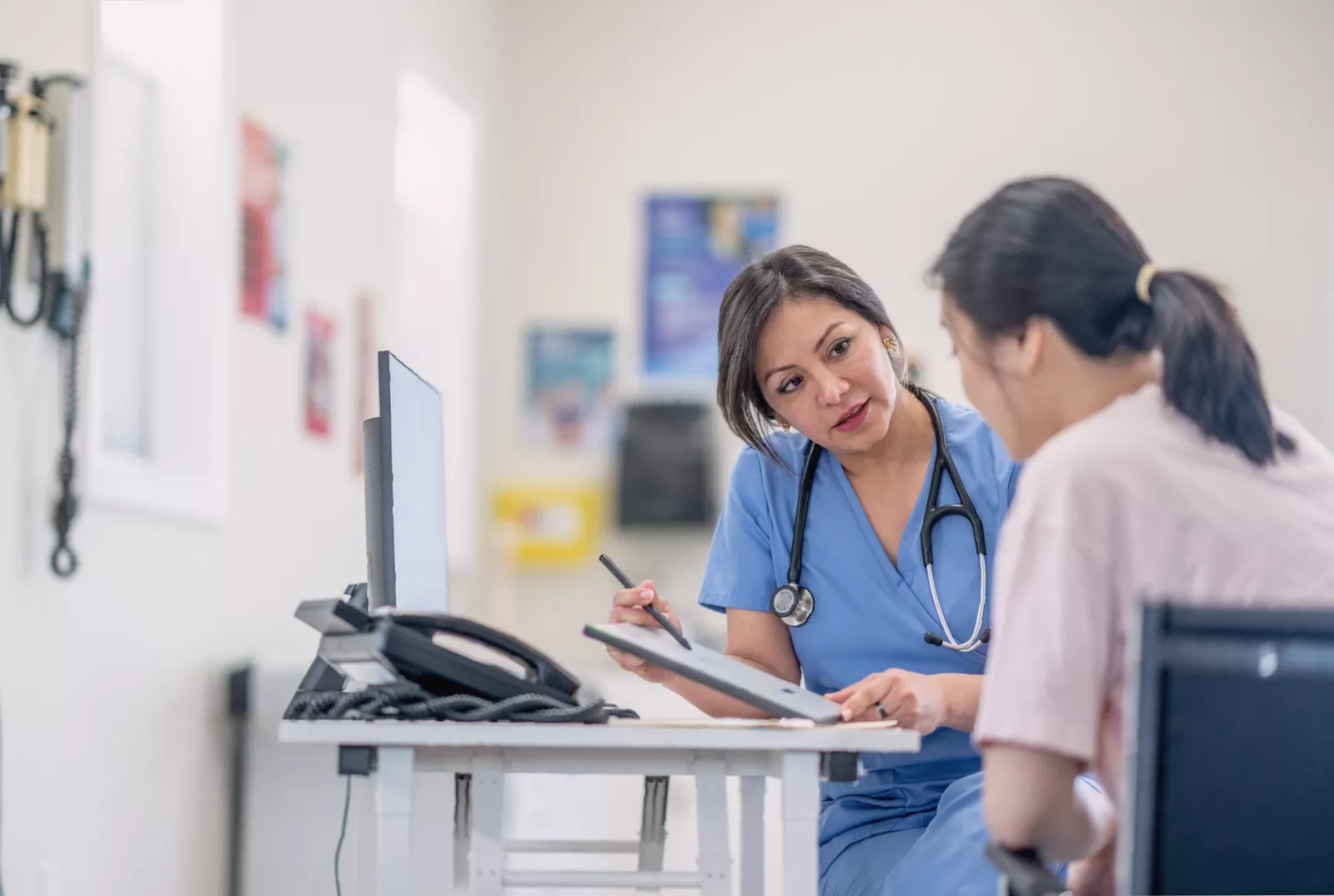 A GP in a consultation room providing reassurance to a patient.