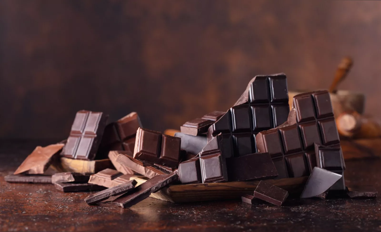 A selection of dark chocolate bars and cocoa powder on a table.