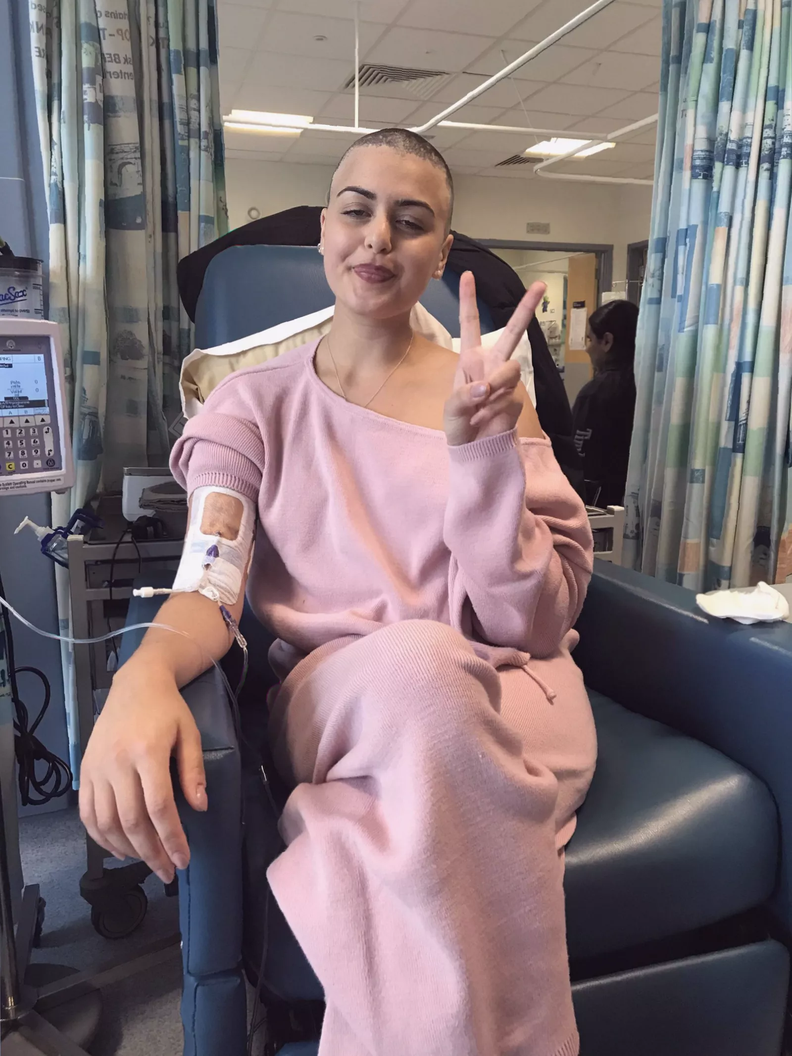 A person undergoing chemotherapy treatment in a hospital room.