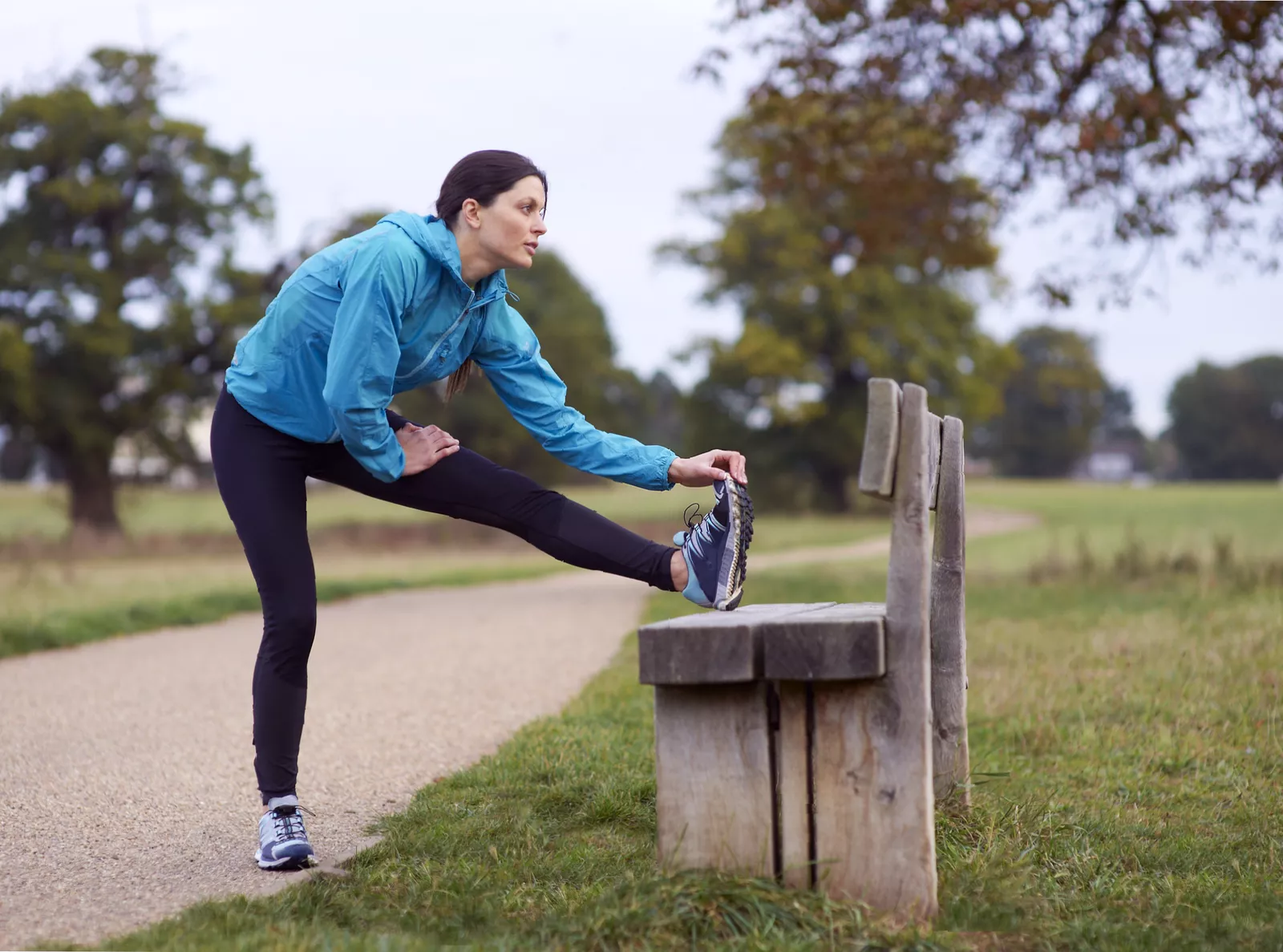 A runner checking their watch while training on a suburban street.