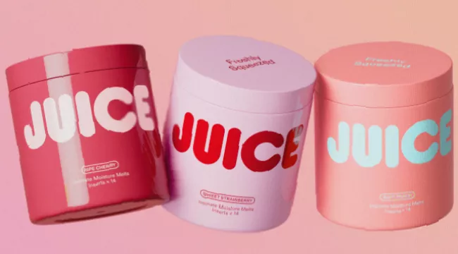 Assorted fruit-scented intimate care products displayed on a pastel countertop