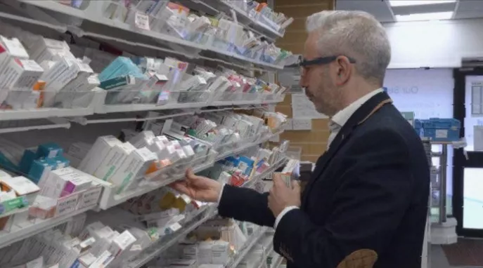Rows of medicine boxes on shelves in a community pharmacy in England