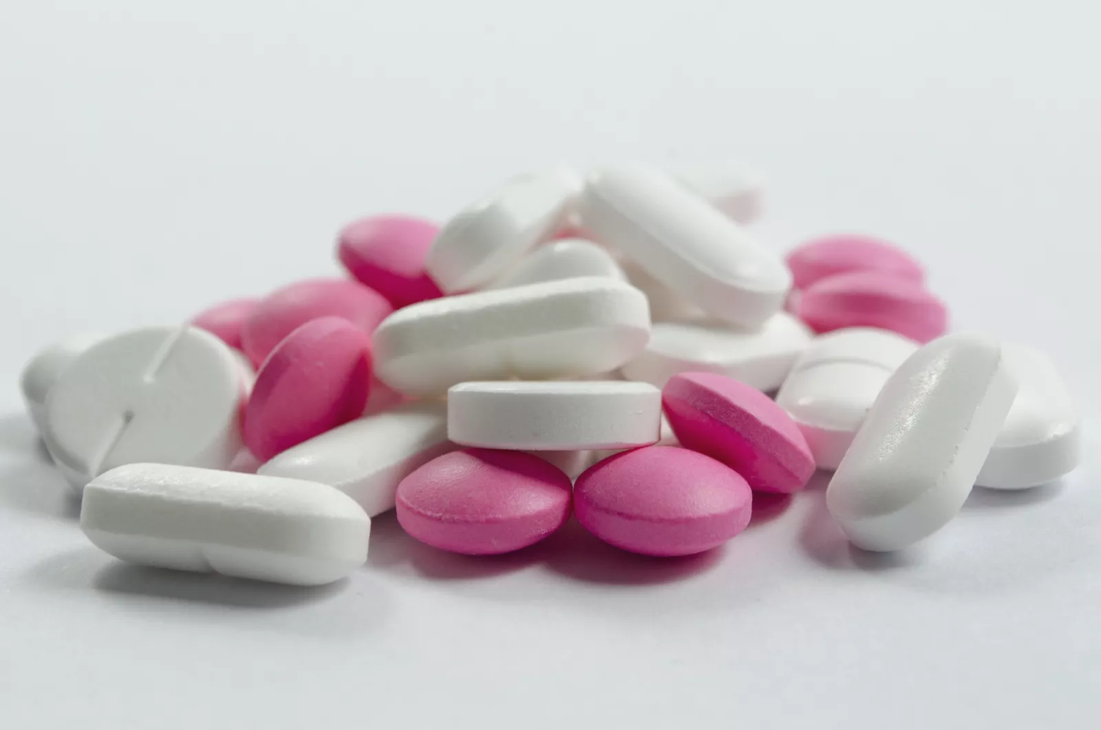 A customer at a pharmacy counter paying for over-the-counter painkillers