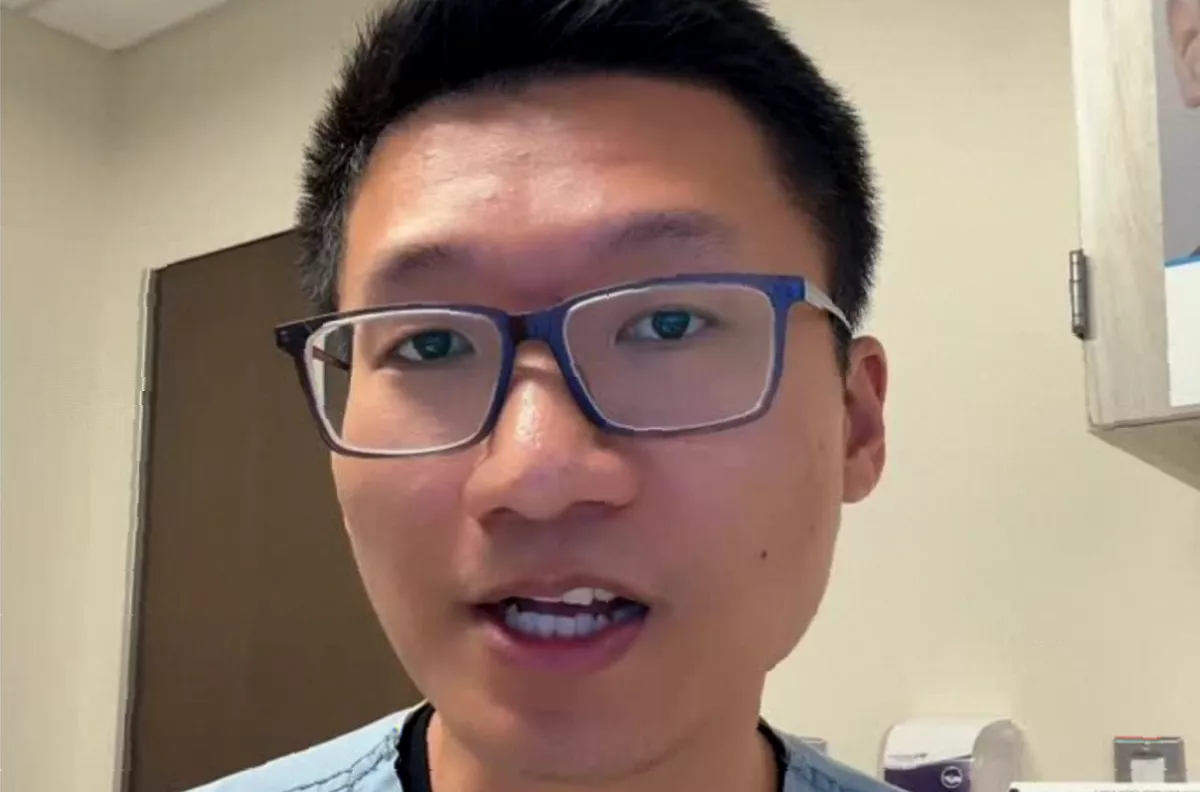 A hand squeezing a blemish in the facial "triangle of death" area