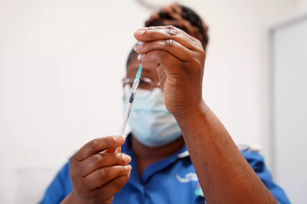 An elderly person receiving a vaccination at an NHS clinic.