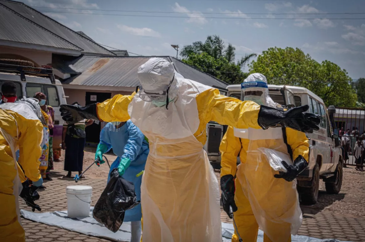 A health worker in protective gear stands outside a treatment centre in an Ebola-affected area
