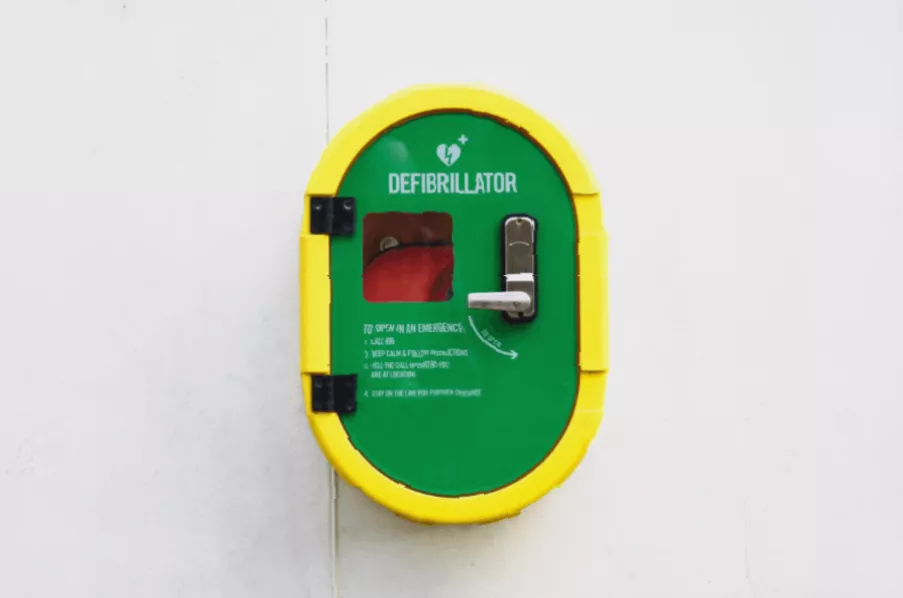 A close-up of an automated external defibrillator inside a vehicle’s glovebox