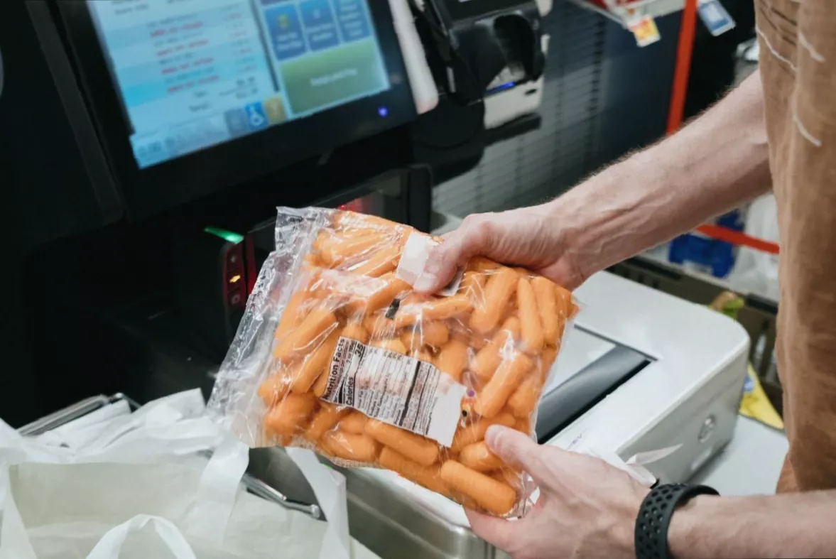A person reading food nutrition labels on packaged goods at a grocery store