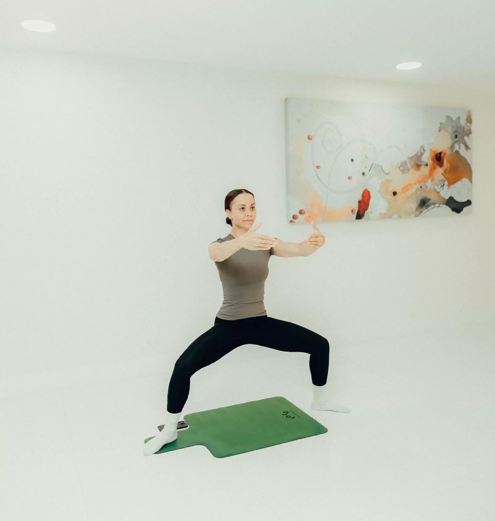A person doing a wall-assisted curtsy lunge for lower-body strength
