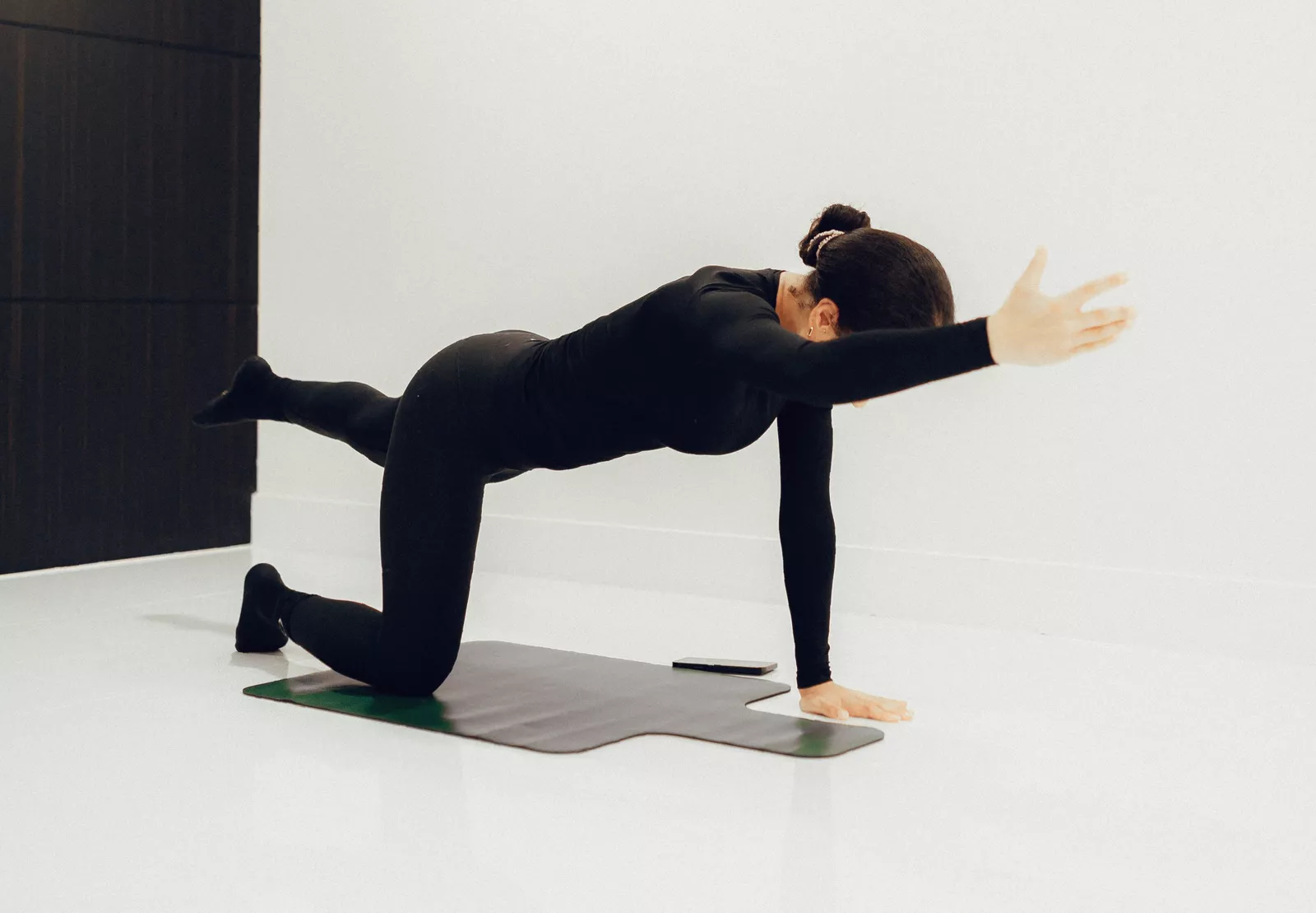 Man holding a hollow body position on the floor for core stability