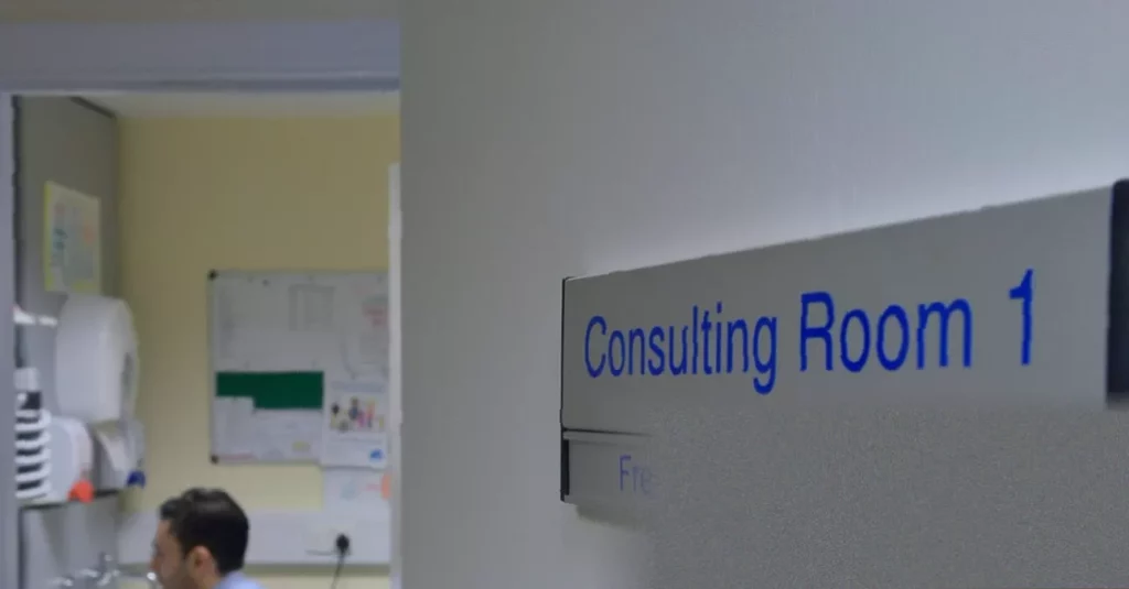Doctor and patient reviewing a unified digital health record on a tablet in a consultation room
