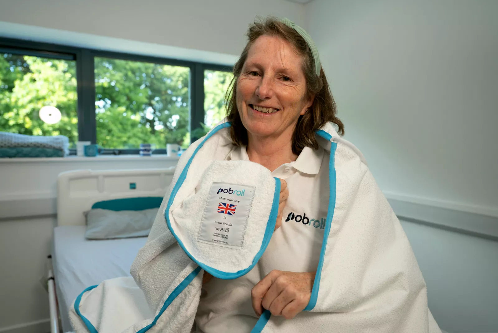 A patient swaddled in a sleeping-bag style towel during personal care