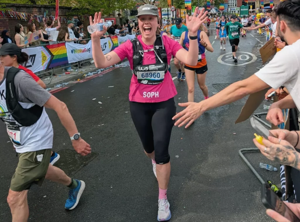 Woman in running gear crosses London Marathon finish line on The Mall