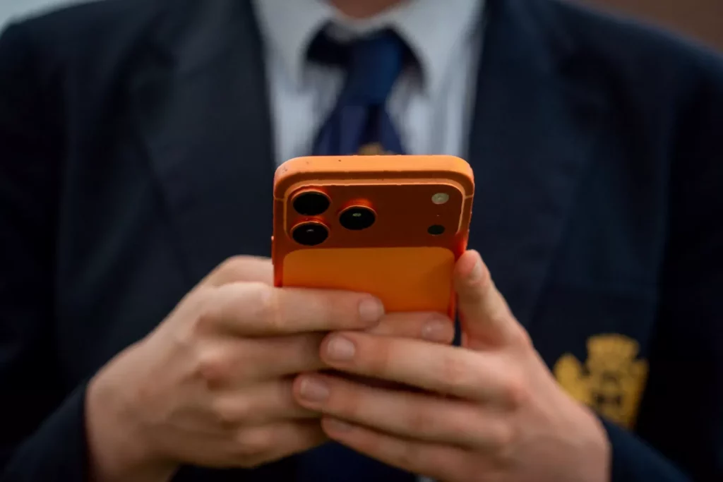 A row of mobile phones on a school desk, symbolising the push for phone-free classroom rules
