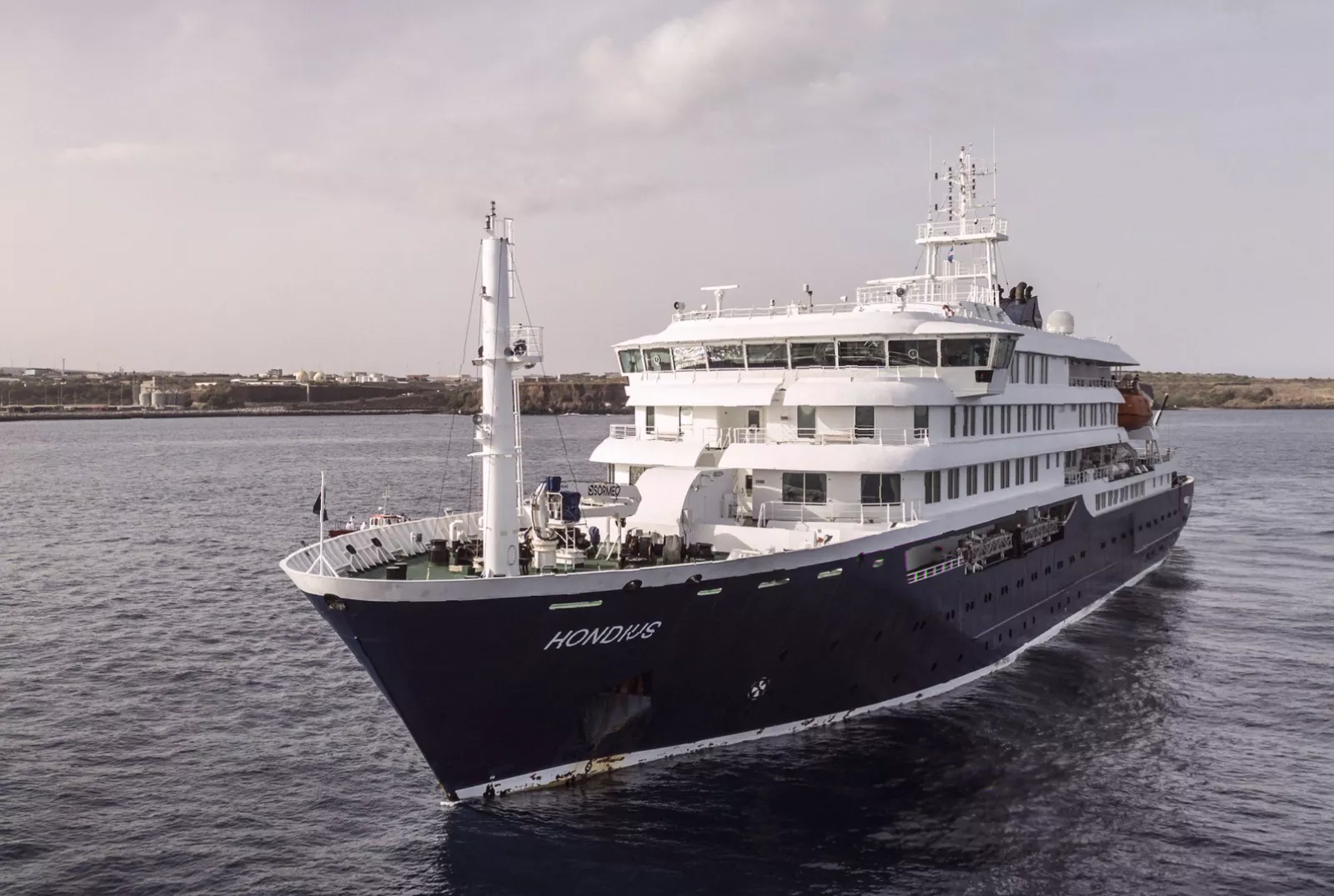 French health officials in protective gear boarding a berthed cruise vessel for inspection