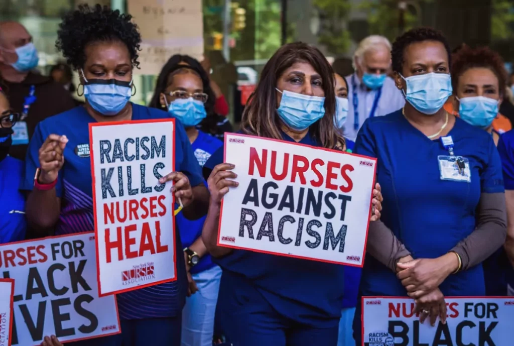 Nurses tell of racist abuse by patients as they press for extra support A Black nurse in a hospital corridor speaking with a colleague after a hostile patient encounter