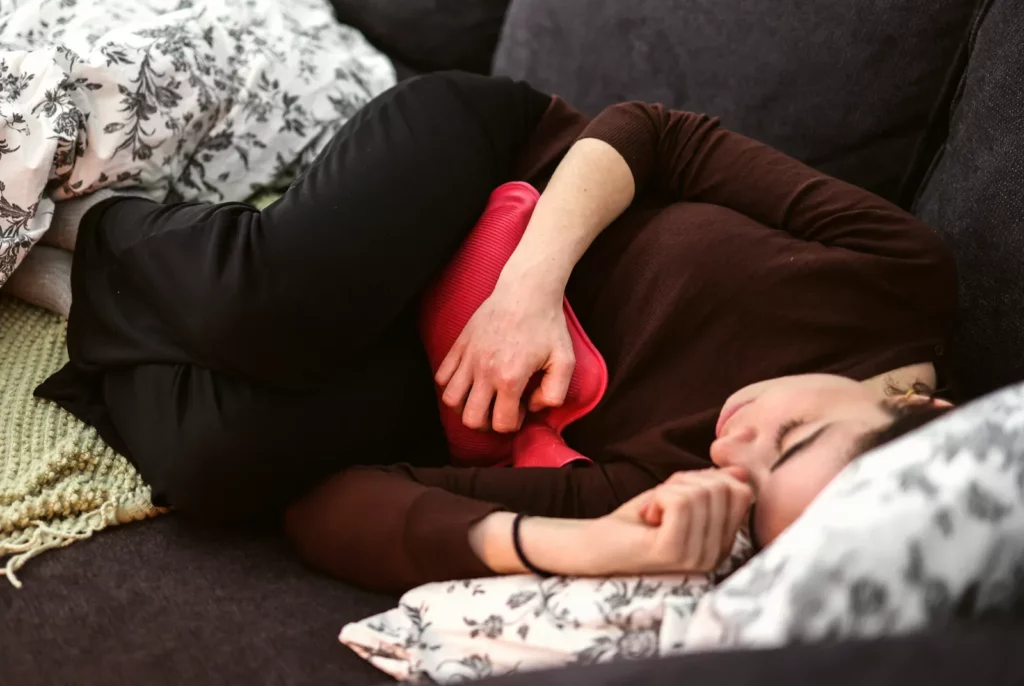 A woman sitting in a doctor's consultation room, discussing health concerns with a physician.