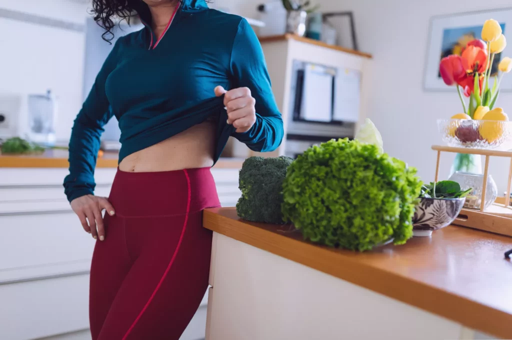 Person performing a standing zip-up exercise in a kitchen