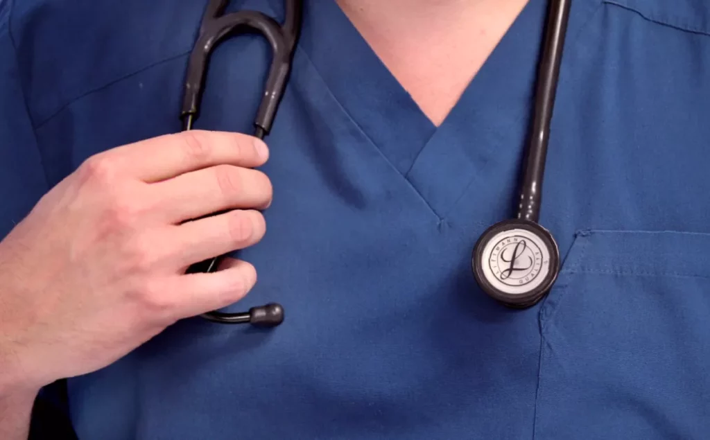Two-thirds of NHS bodies to cut patient services over coming year Empty hospital corridor with closed ward signs and dimmed lighting