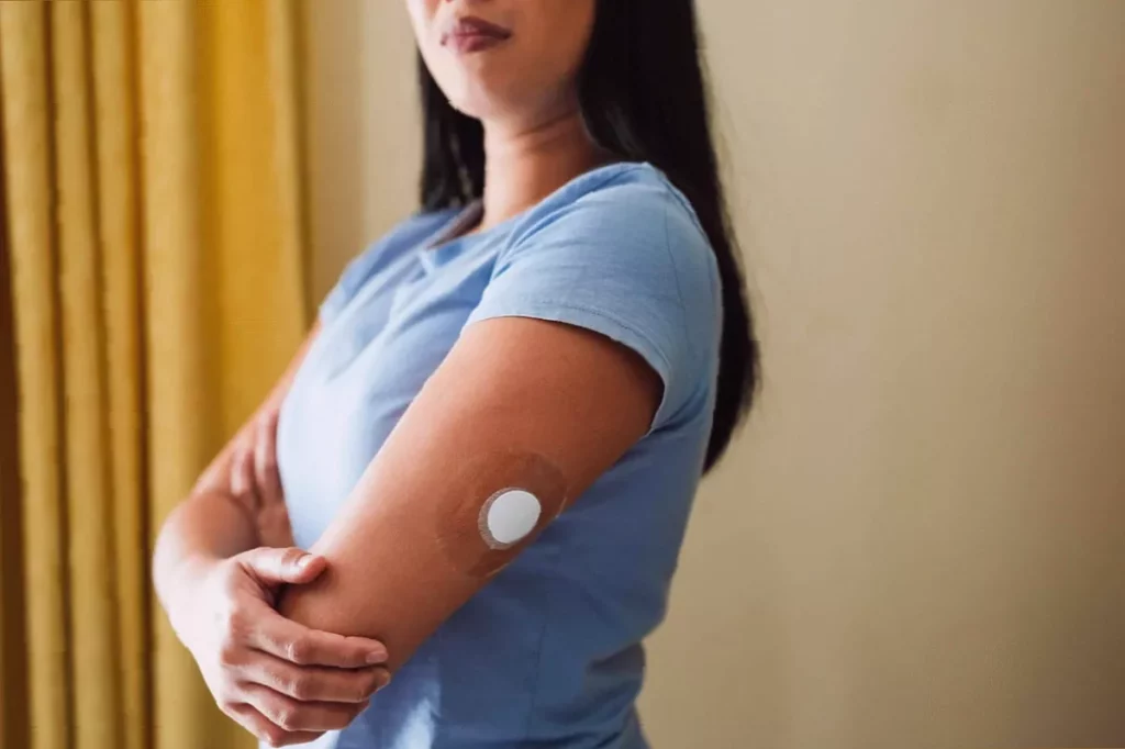 A woman receiving a blood test for HbA1c levels at an NHS clinic