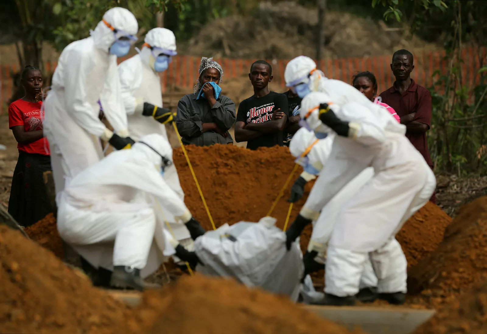 Medical staff carrying out a safe burial procedure for an Ebola victim in an affected region