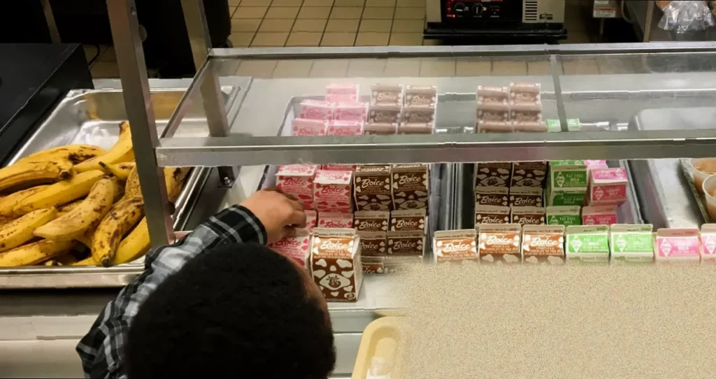 A school cafeteria lunch tray with a banana next to a carton of milk