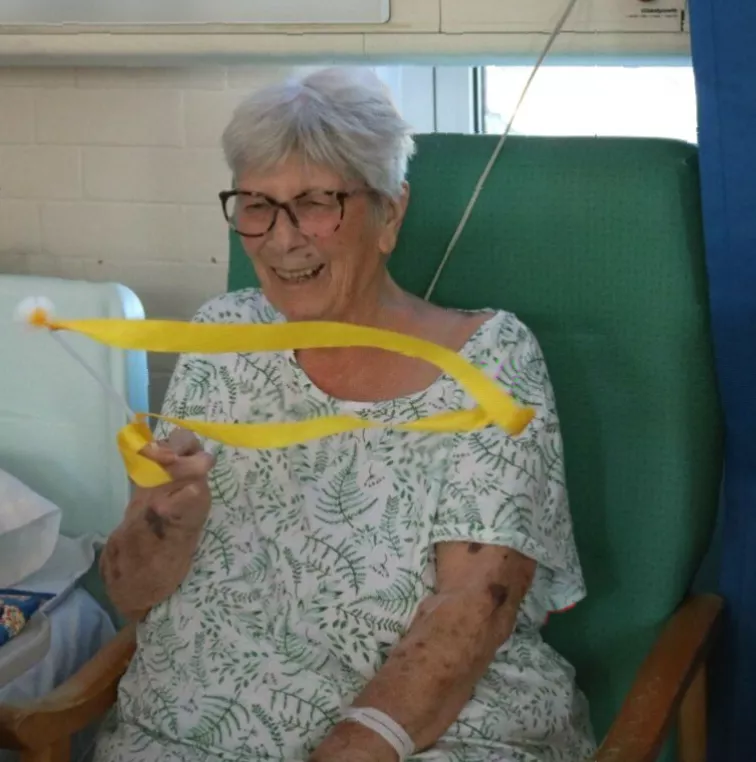Elderly patients and staff joining a group dance activity in a clinical setting