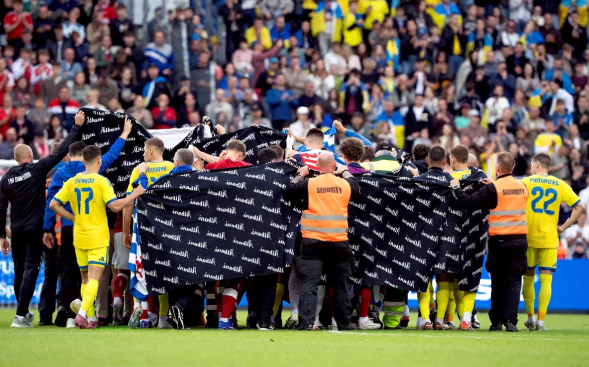 Medical staff rushing to attend to a fallen footballer during an international friendly