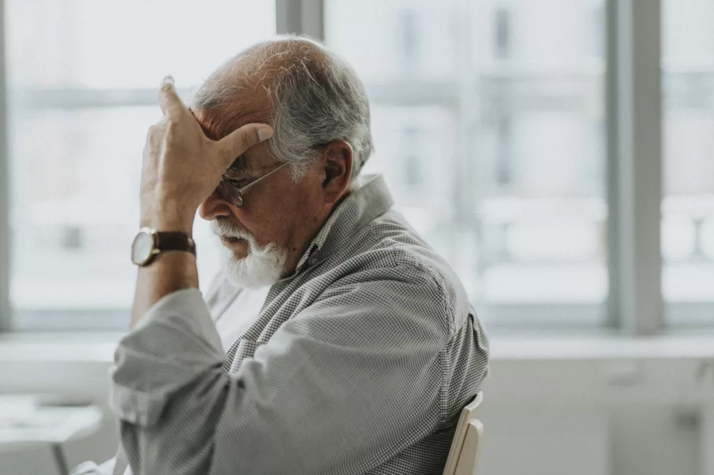 Four in five frail pensioners missing essential NHS checks due to regional disparities An elderly patient sitting in a GP waiting room with a NHS poster on the wall.