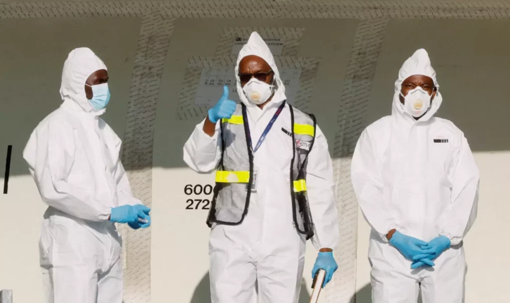NHS staff restocking personal protective equipment in a hospital storage room