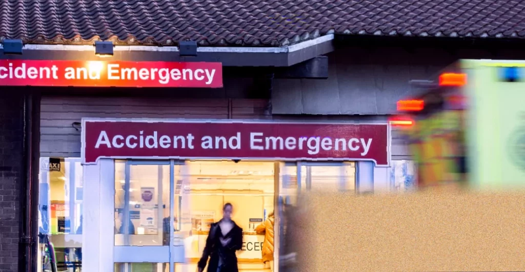 Patients using a digital triage kiosk in a busy NHS emergency department waiting room