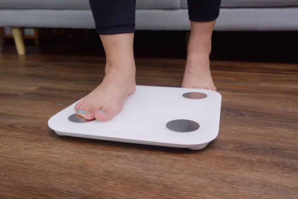 Once-a-day pill results in 10 per cent body weight reduction Clinical trial participant holding a small white tablet and a glass of water