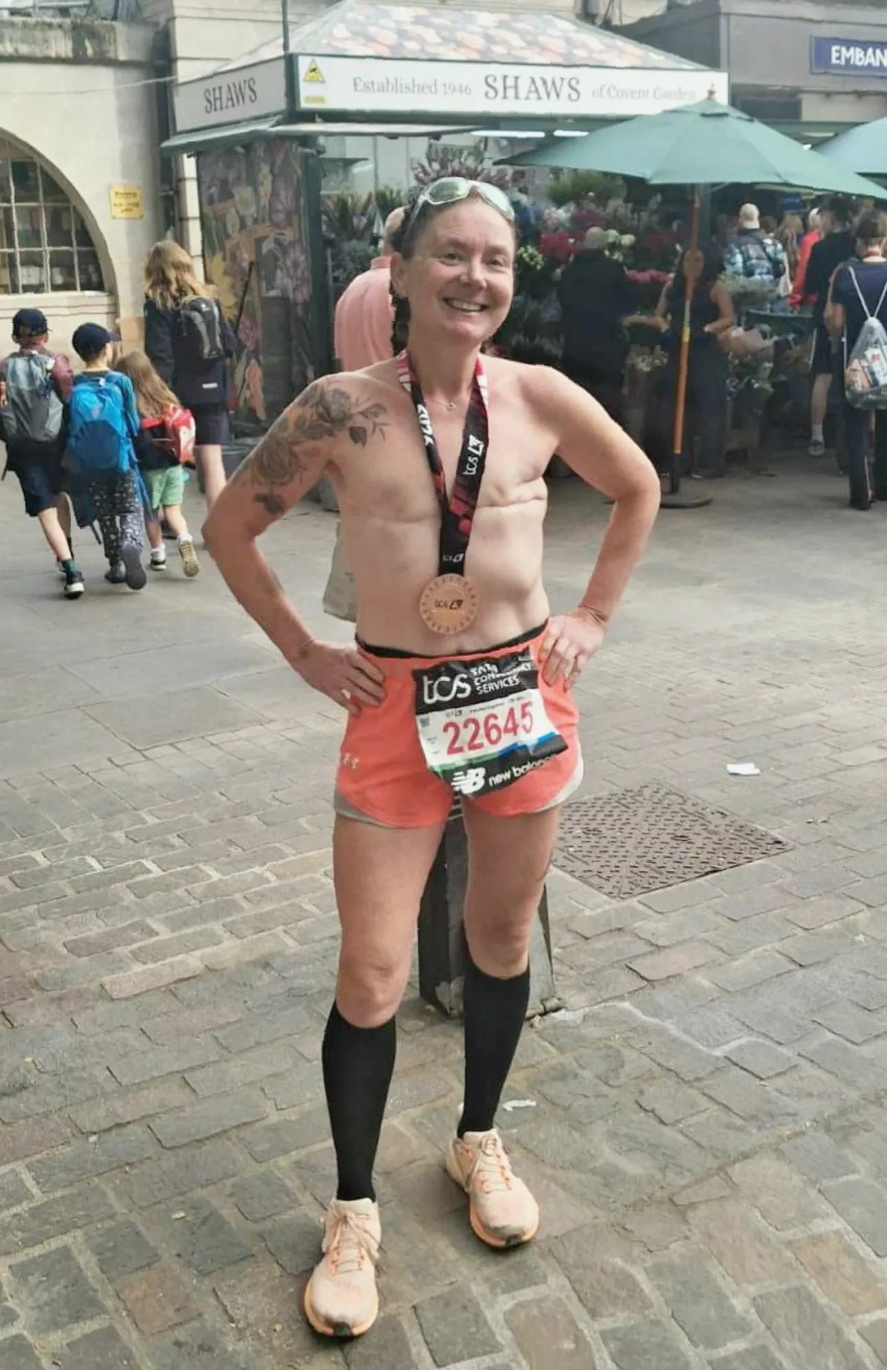 A breast cancer survivor running topless along a coastal path
