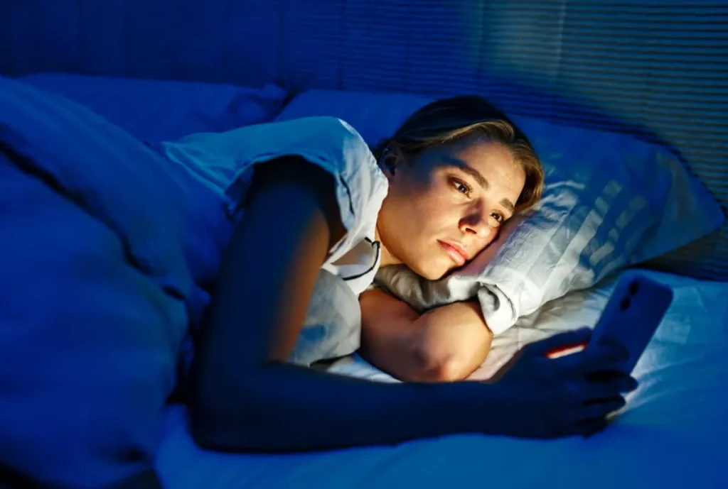 Middle-aged man lying awake in a dimly lit bedroom, unable to sleep