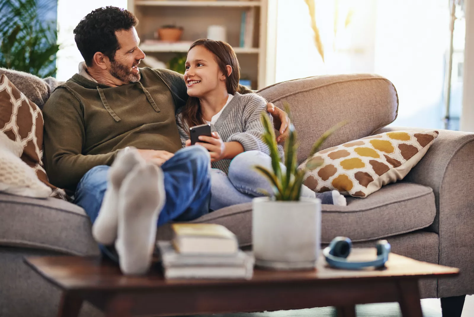 A father and daughter reading an age-appropriate book about puberty together at home