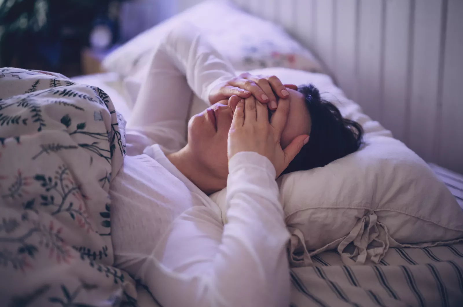 Woman checking her sleeping routine on a digital alarm clock in the morning