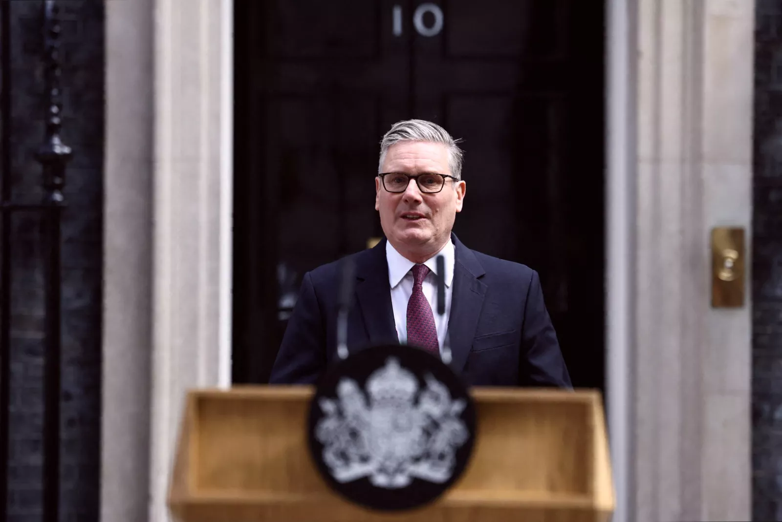A tired-looking figure sitting alone in a government meeting room