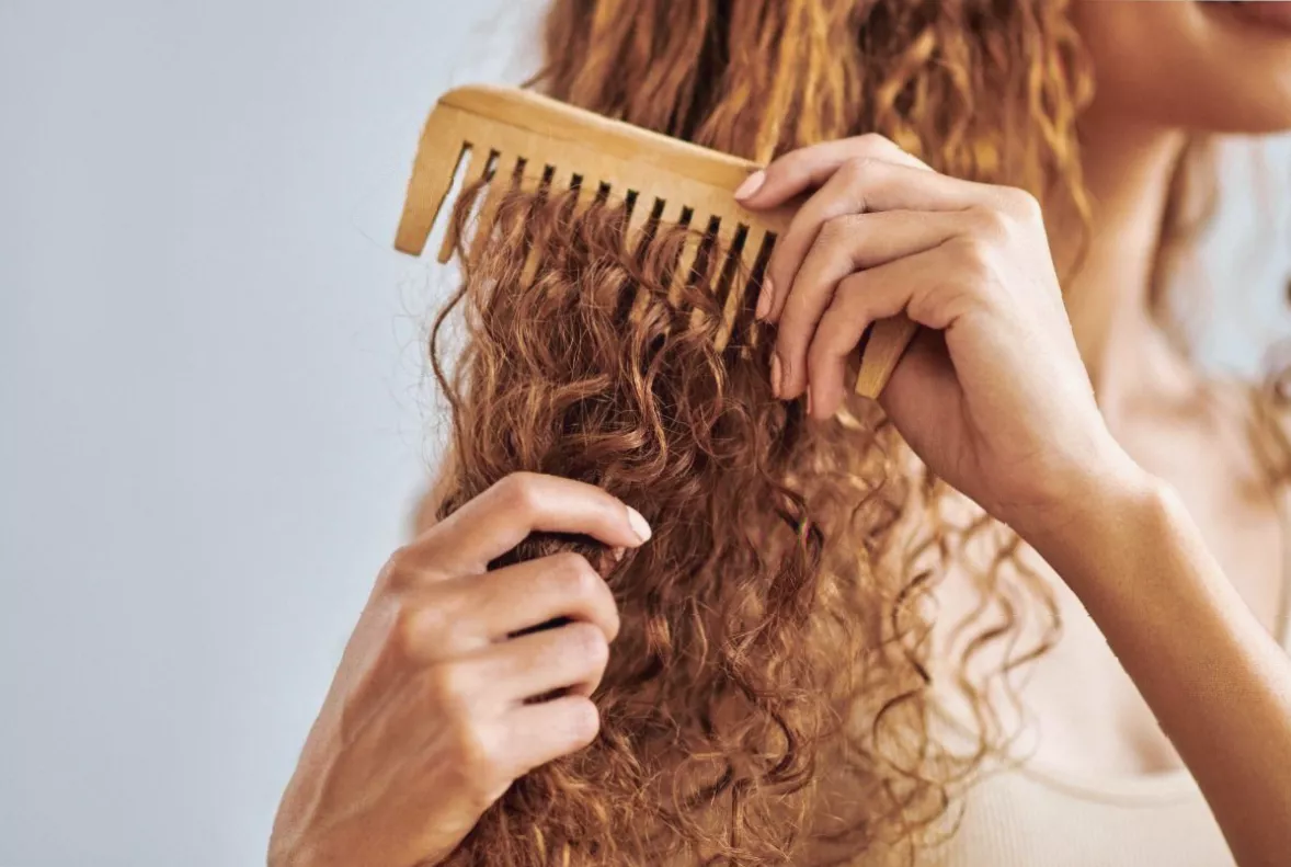 Hair being rinsed in a shower stream with visible smoothness and shine