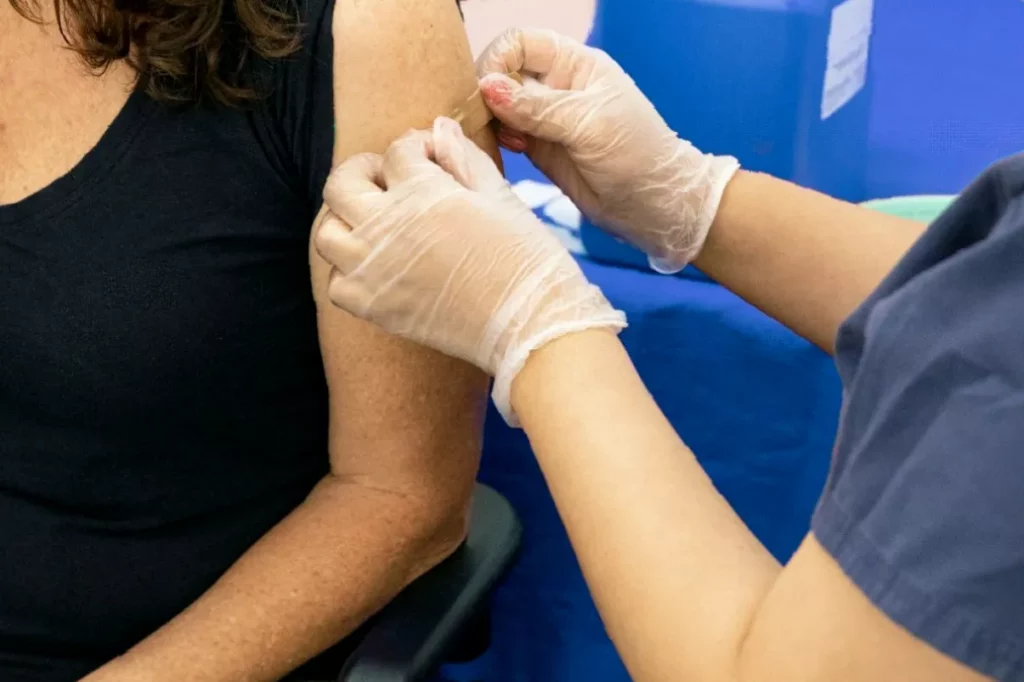 An NHS nurse preparing an RSV vaccine injection in a GP surgery consultation room